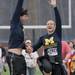 Andres Tamez and Jackie Conliffe, of Ann Arbor, slap the overhead banner as they finish the 5-kilometer Big House Big Heart Run race at the 50-yard line of Michigan Stadium April 15. Chris Asadian | AnnArbor.com